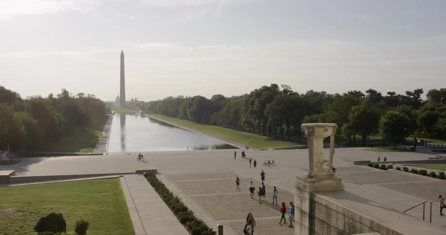 People are walking on the national mall in Washington DC near the Lincoln Memorial in Washington monument
