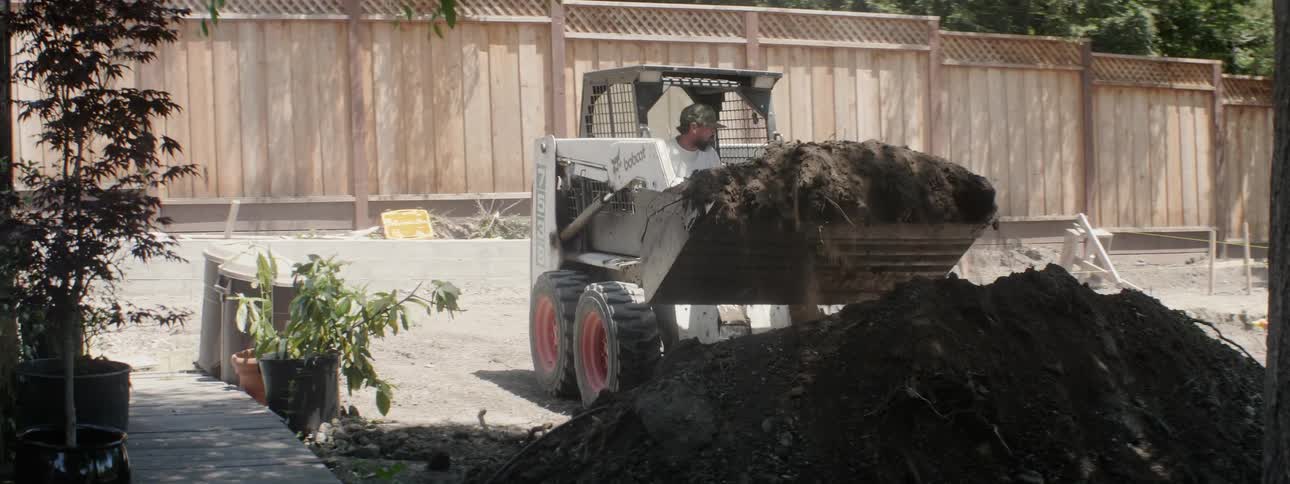 The bulldozer lifts piles of soil