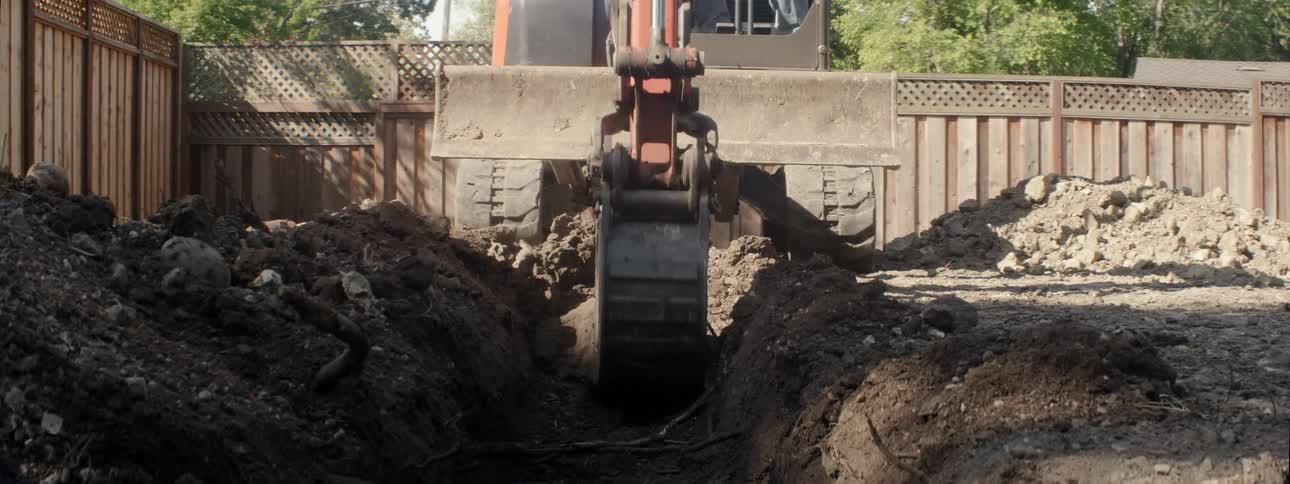 The construction vehicle digs a long trench