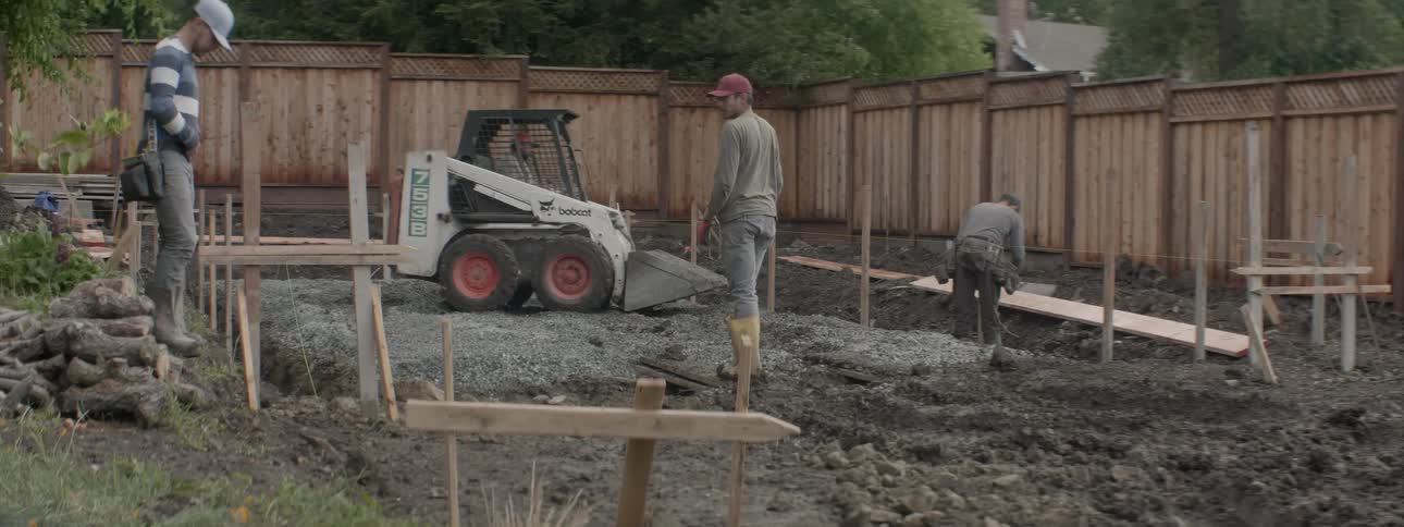 Machinery and men move around at a construction site