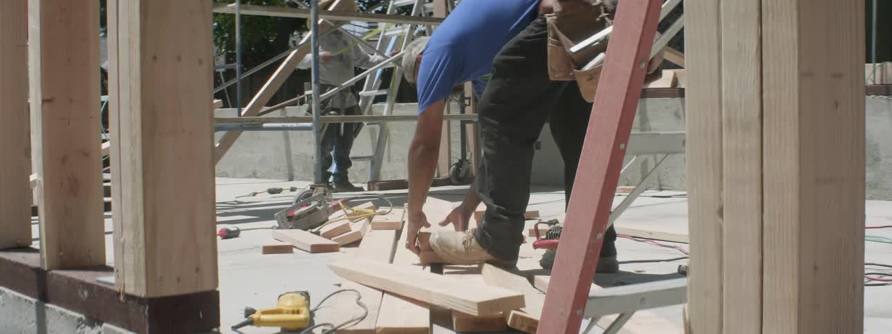A man saws wood at a construction site