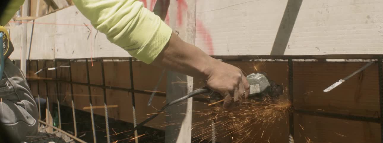 A worker uses a power tool at a construction site
