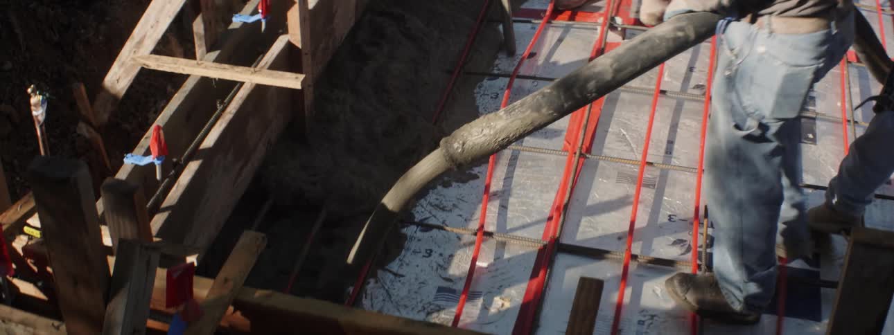 The construction worker shoots cement all over with a tube
