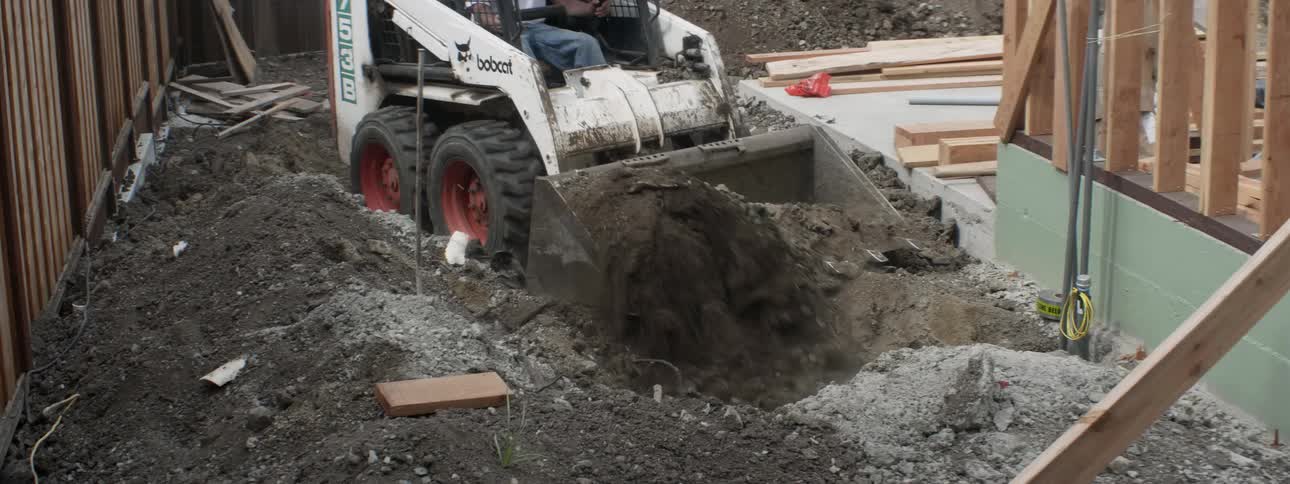 A bulldozer digs through dirt at a construction site