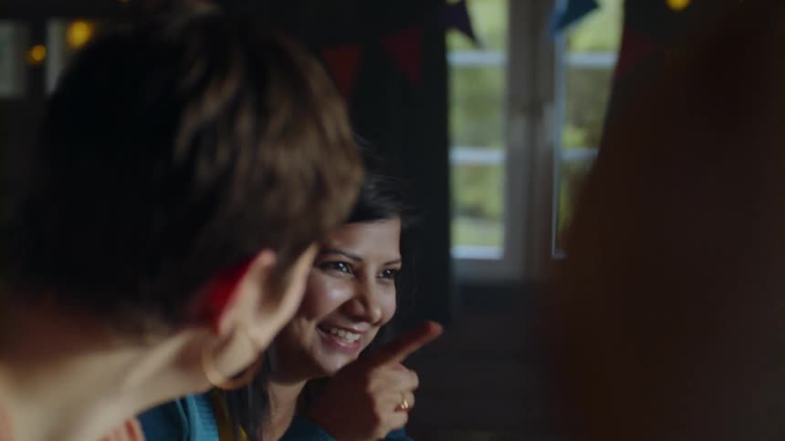 Two women smile and laugh indoors