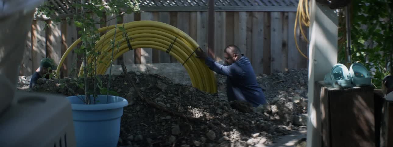 A man rolls tubing at a construction site