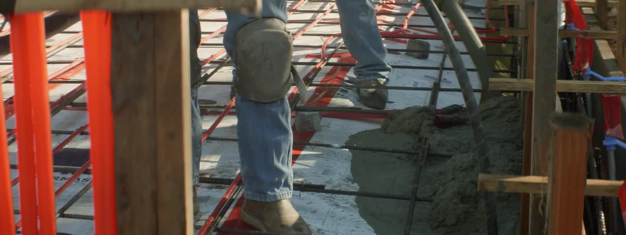 Workers lay concrete at a construction site