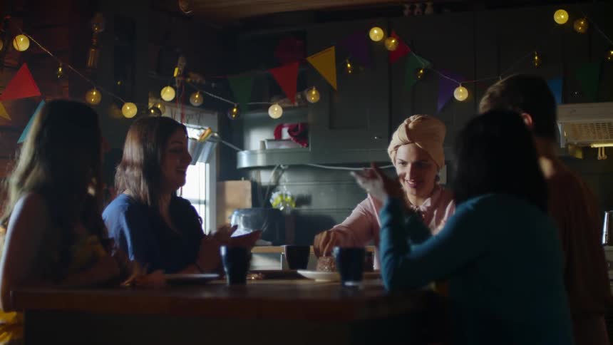 A woman cuts a birthday cake at a party