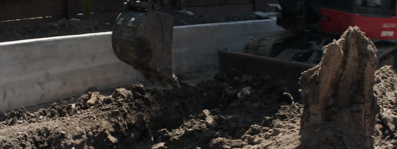 The construction vehicle digs deep and moves the soil