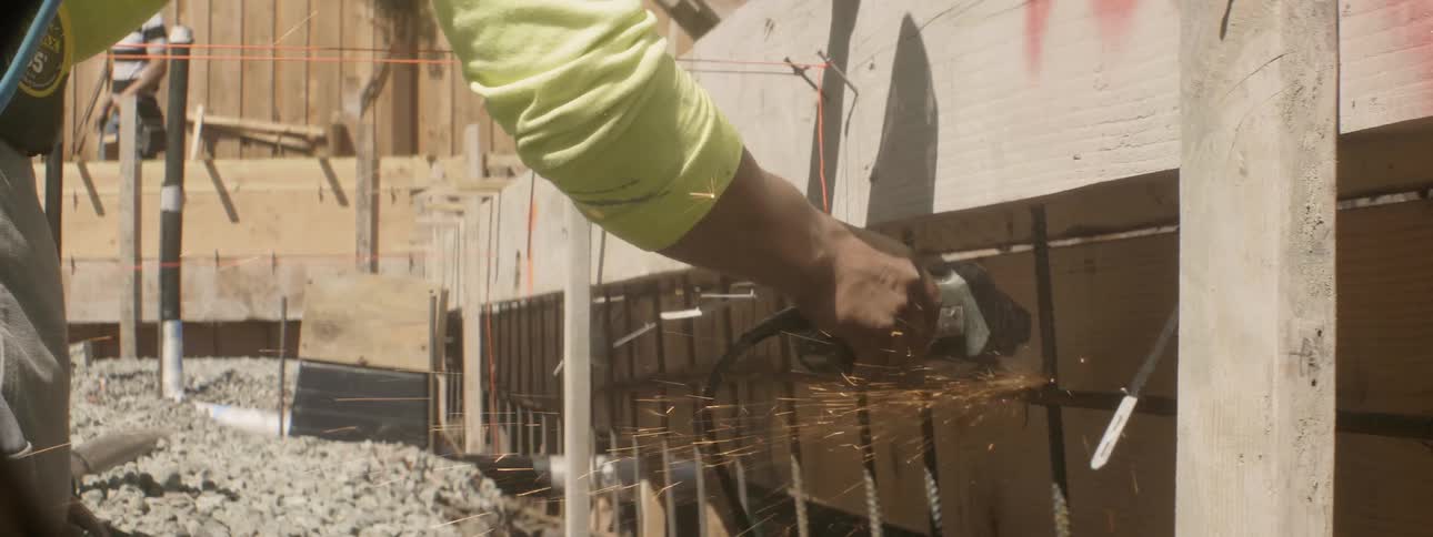 A worker uses a power tool at a construction site