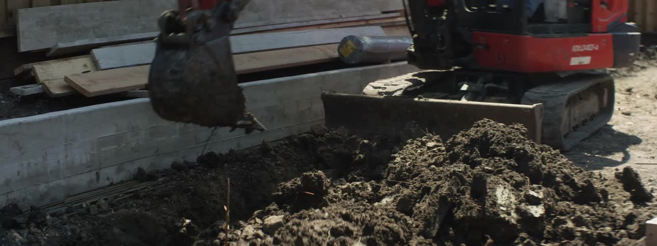 An excavator digs up dirt at a construction site