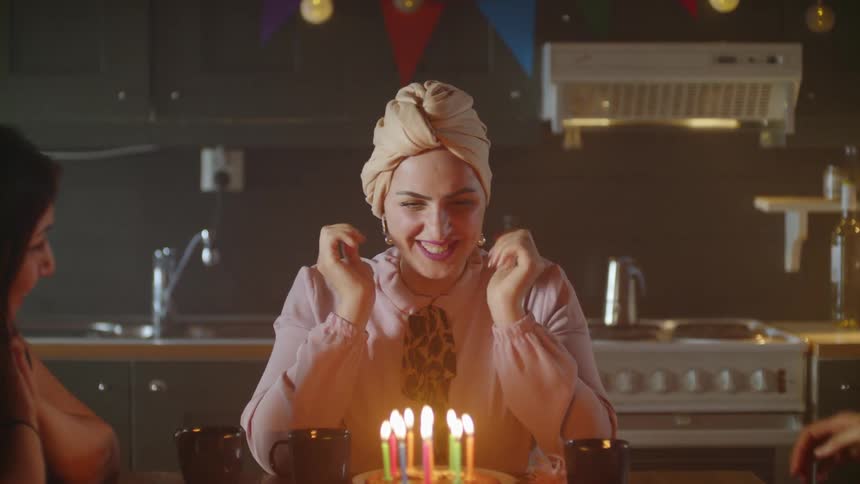 A birthday cake with candles is served at a party