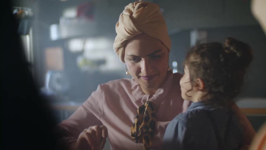 A woman feeds a young girl cake