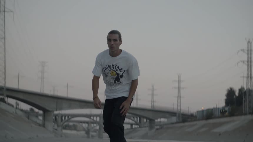 The man is skateboarding before he makes a jump