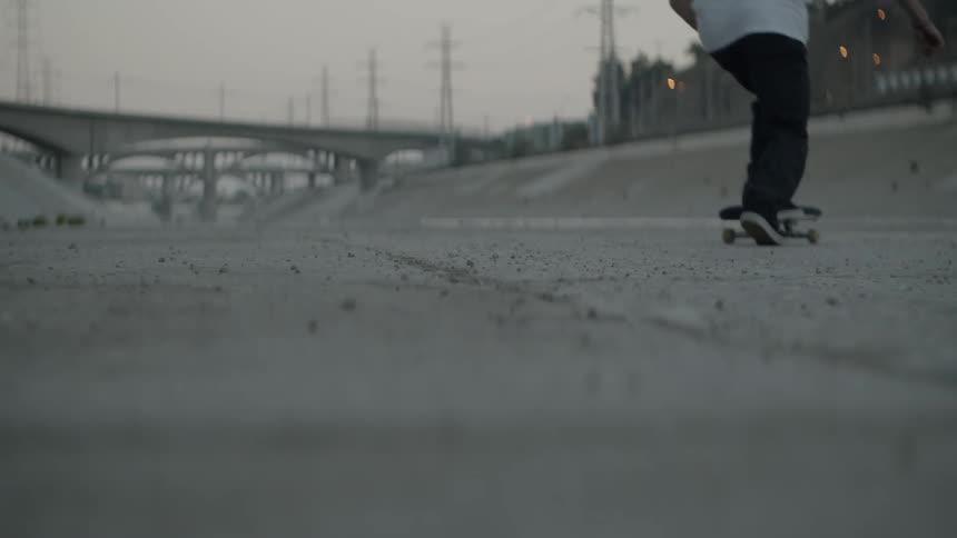 The person runs over and jumps on his skateboard