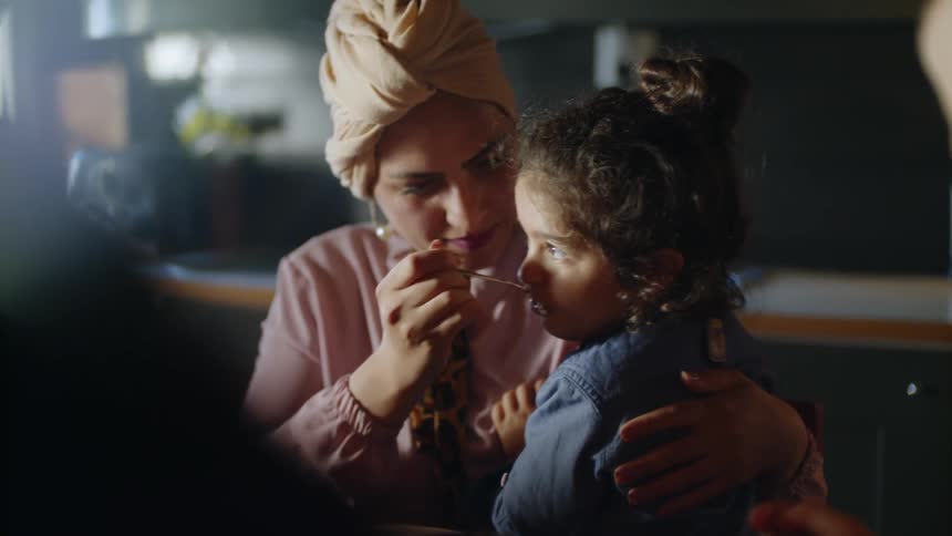 The woman feeds a child in her arms