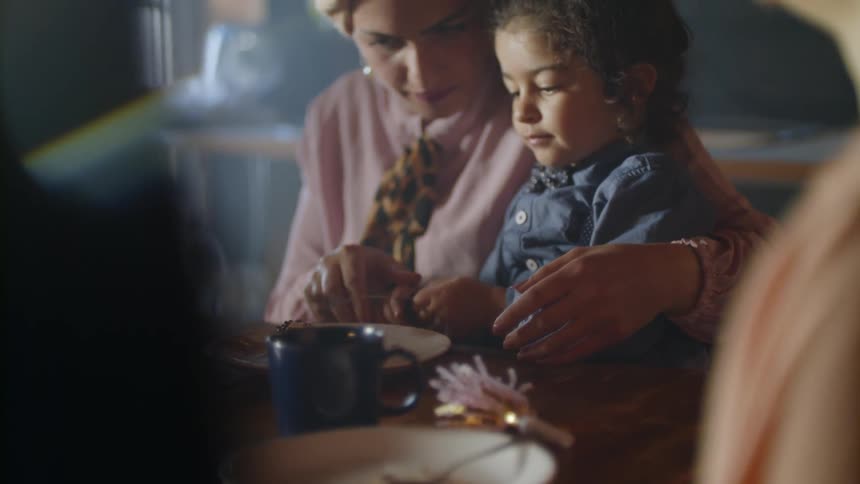 A young girl eats birthday cake at a party