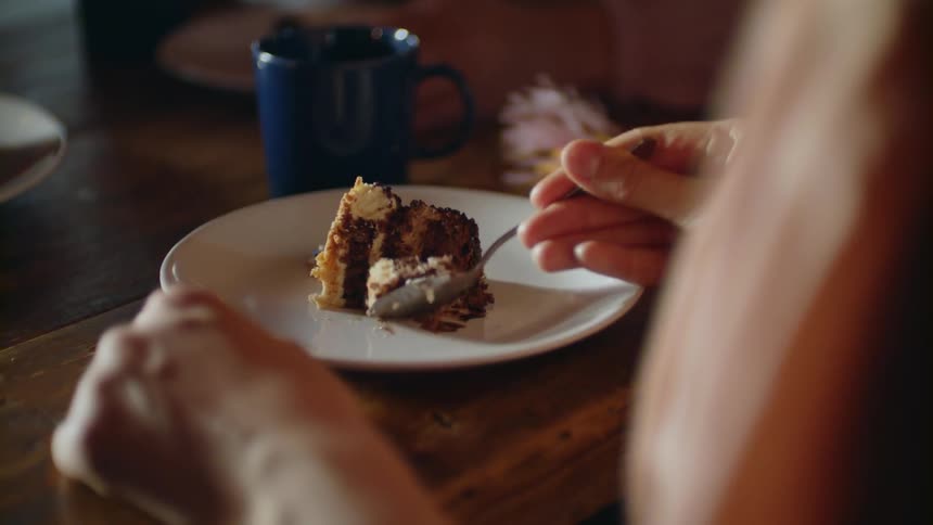 Person cuts into a piece of cake and eats a bite