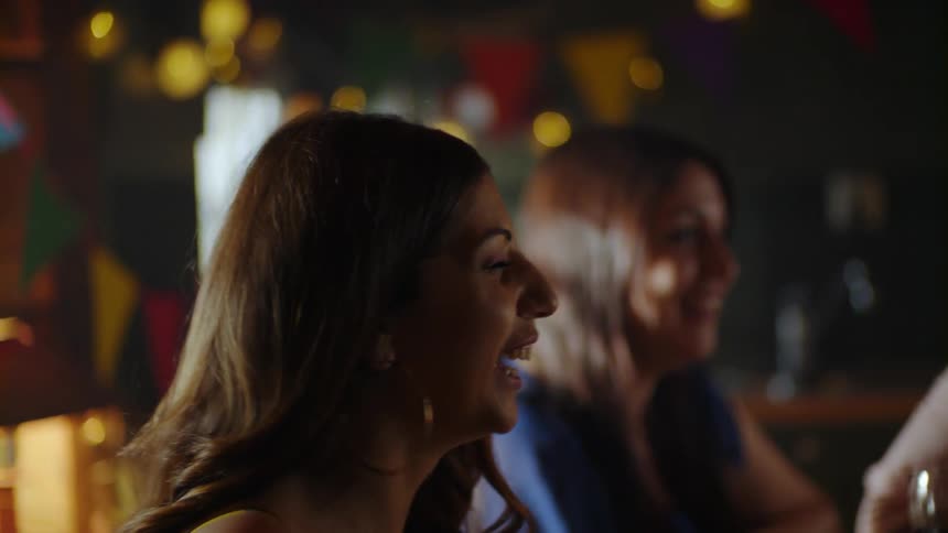 The women laugh and talk at the party