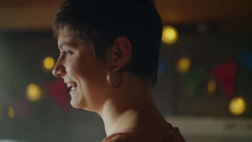The woman laughs and talks to others in the room