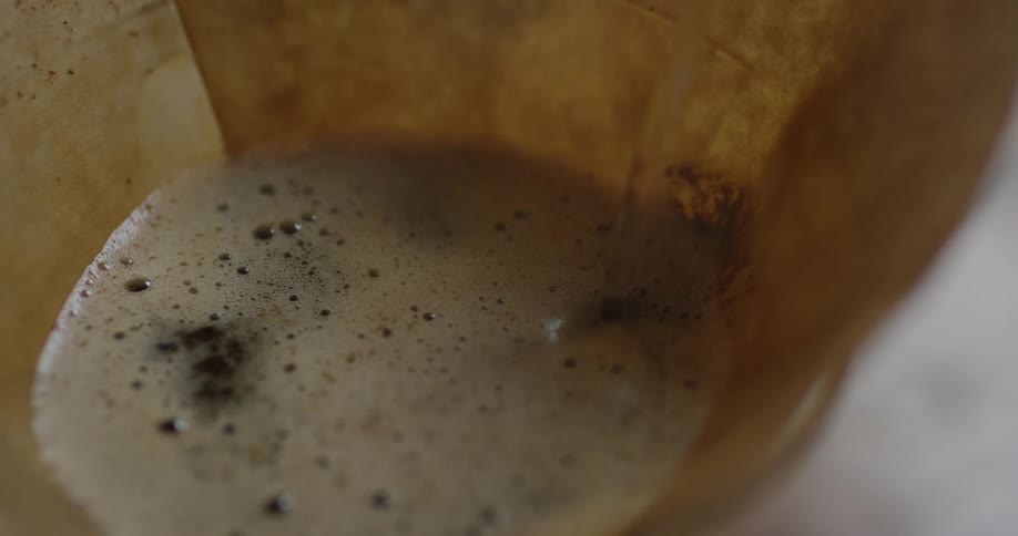 A paper funnel with liquid being poured in it