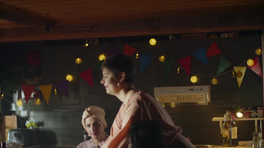A woman is standing at the table talking to others