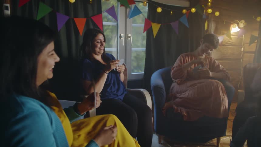 Several woman sit in chairs playing cards