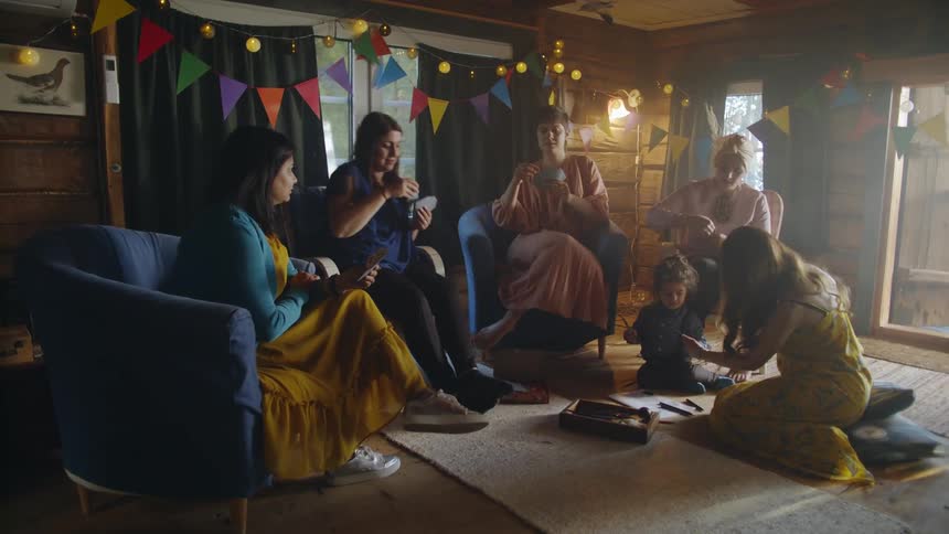 A group of women sit in a circle playing a card game
