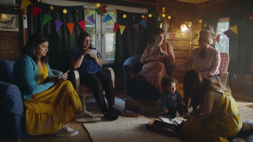 The room is decorated for a party with women sitting all around