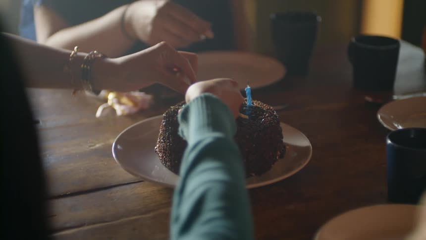 Women take the candles off a birthday cake