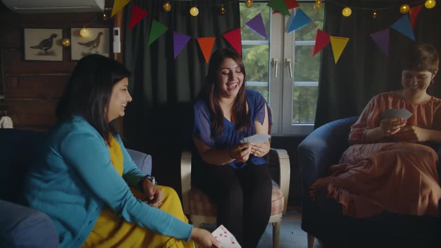 Women smile while playing cards at a party