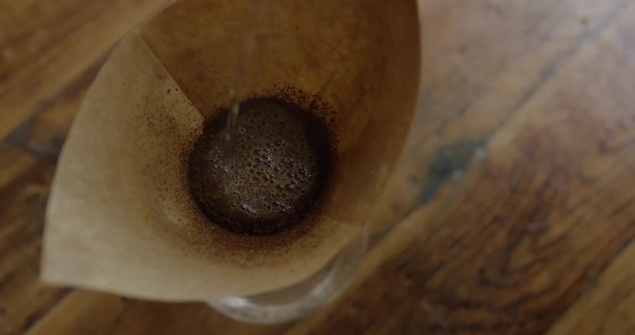 Hot water pouring into a filter filled with coffee