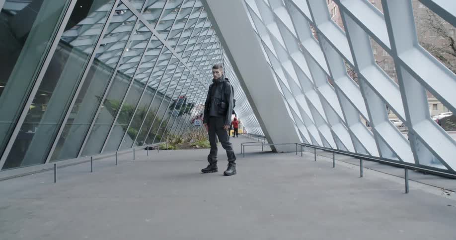 Man stands in the hallway of a glass building