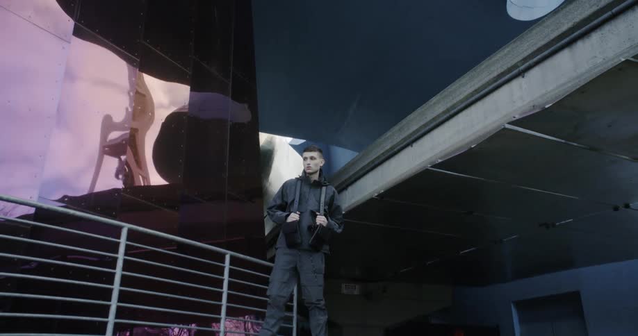 A man poses in front of a building
