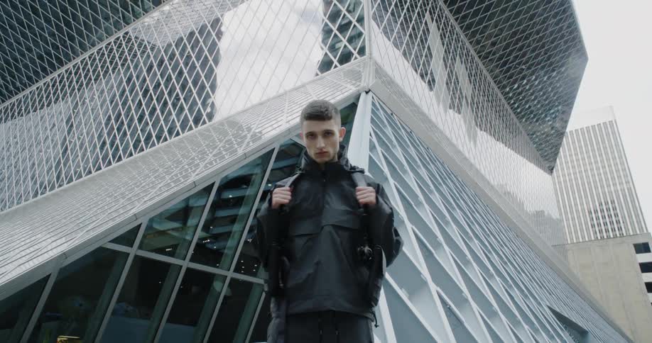 The man stops to pose in front of the building