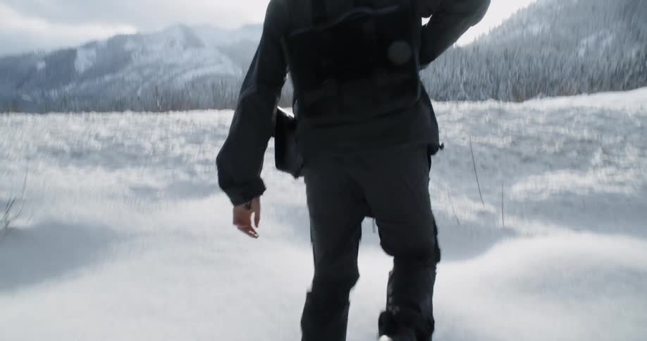 Person walks through the snow on a sunny day
