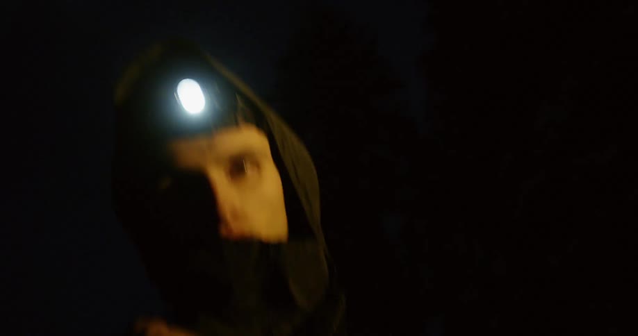A man wears a headlamp while hiking in the dark