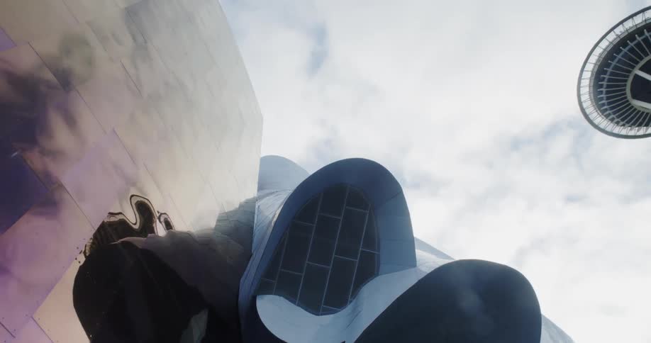 The sky and clouds are reflected on the side of a building