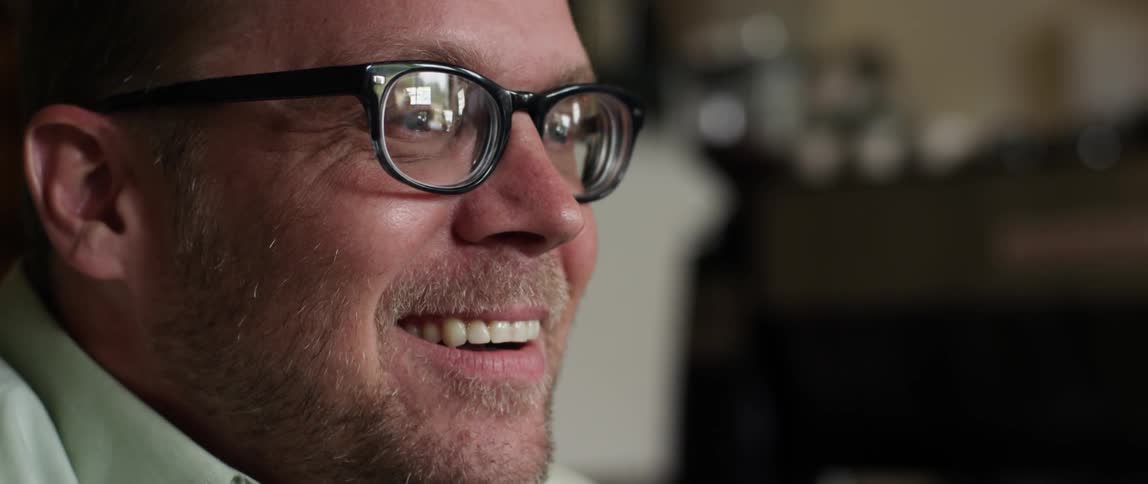 Closeup of a man talking and laughing while having a coffee