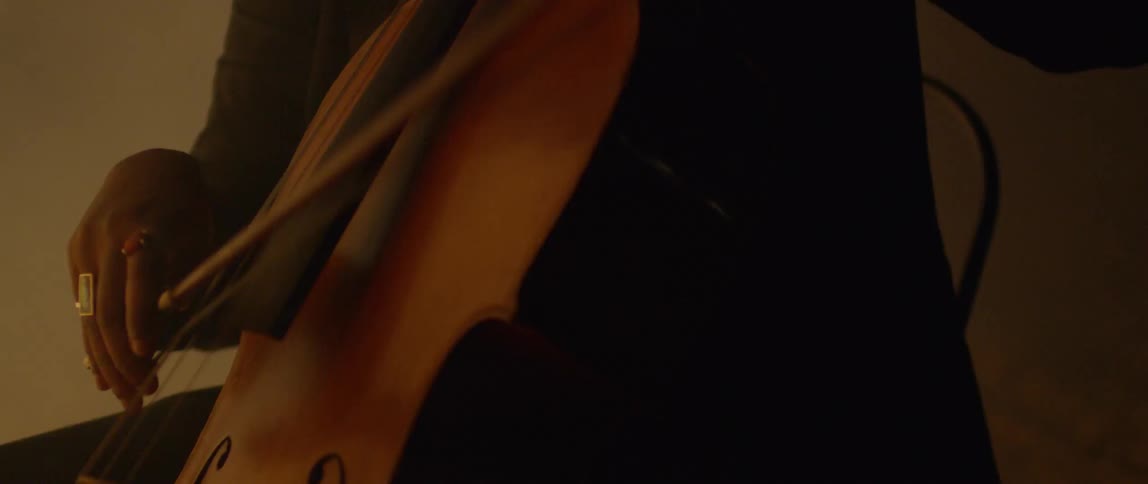 Fog floats around a cellist playing in the dark