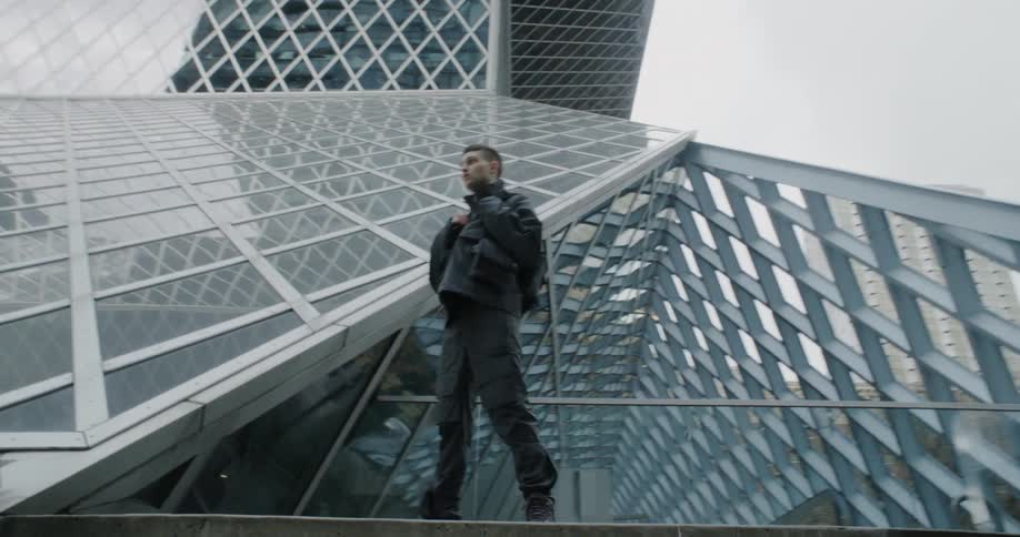 A man poses in front of a building