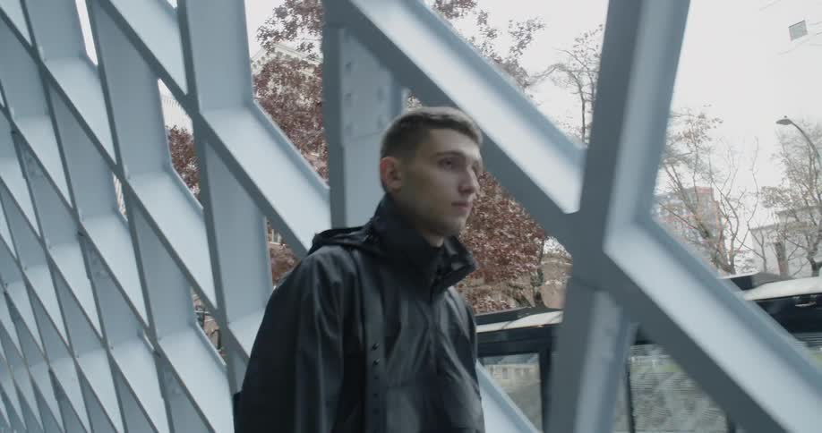 The man walks fast past the building