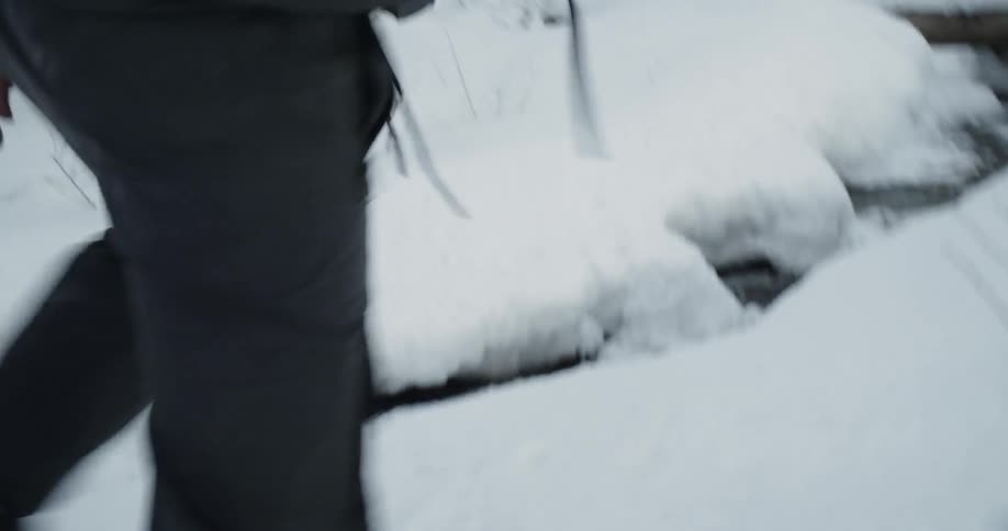 A man walks in snow beneath an overpass