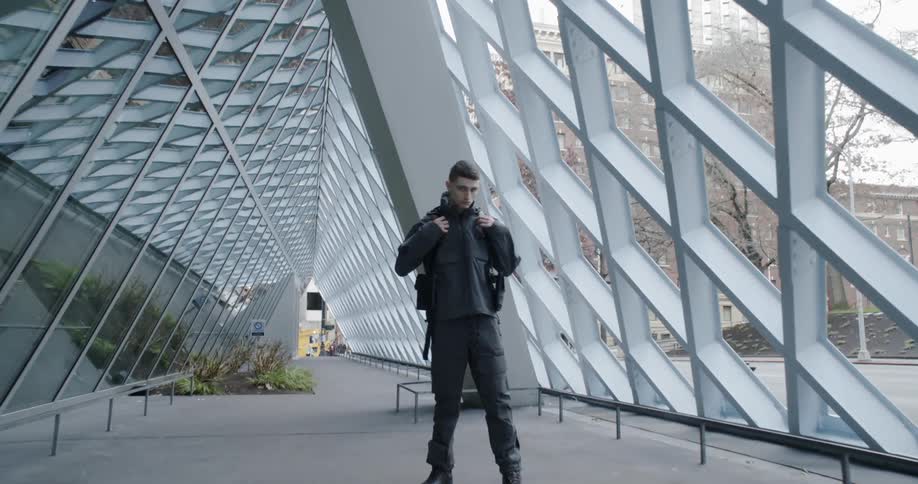 A man poses next to a city building