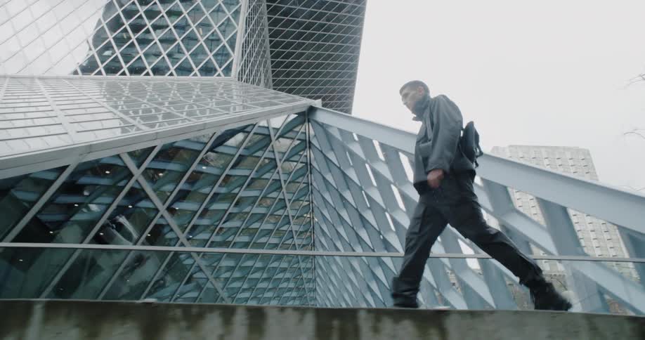 A man walks past a tall building