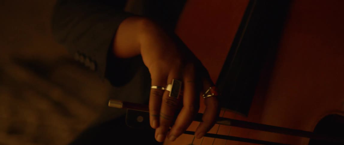 A cellist plays in the dark