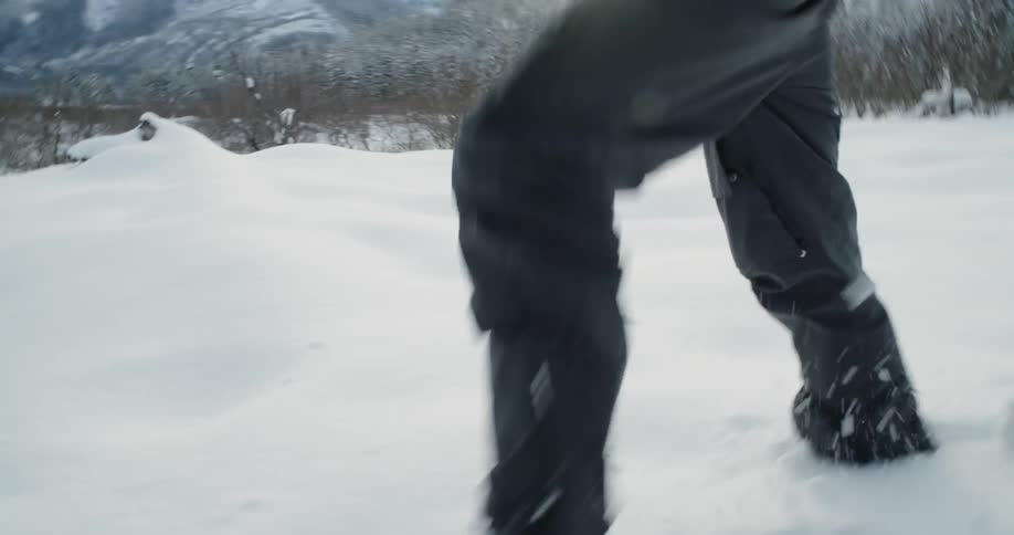 Man is walking through deep snow in mountain wilderness