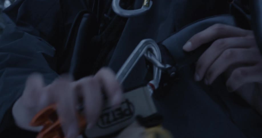 A man clips gloves onto a belt