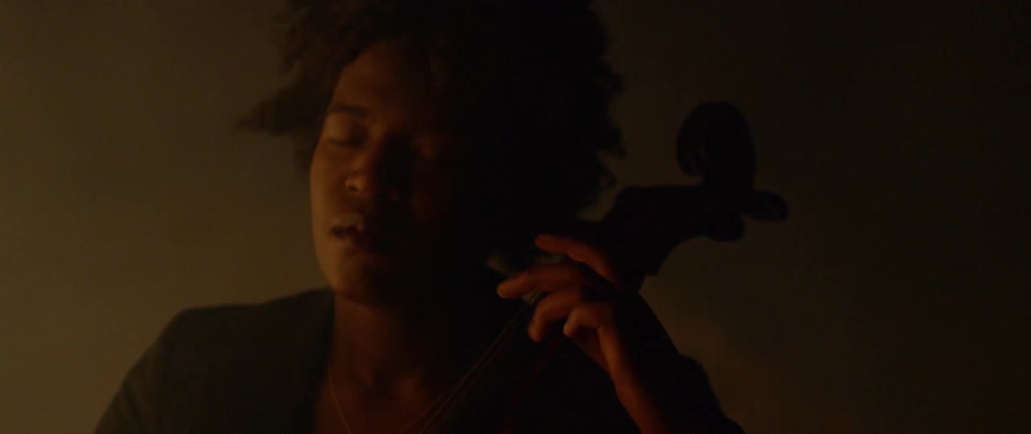 Fog floats around a cellist in the dark