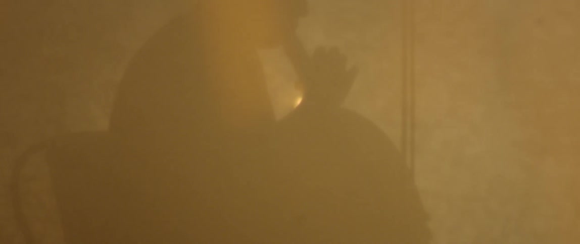 Fog flows around a cellist in the dark